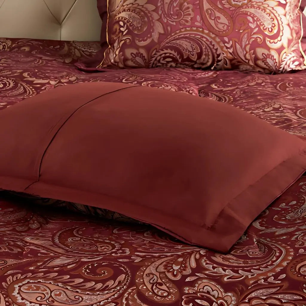 Detailed jacquard weave paisley pattern in rich red gold silver tones on luxury comforter fabric