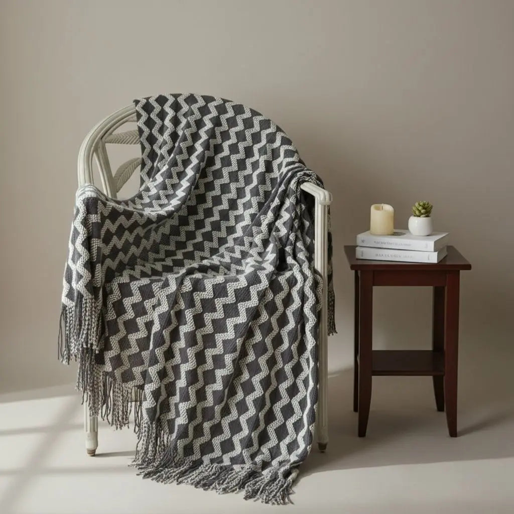 Chenille throw blanket with geometric knit pattern and tasseled edges in neutral tones