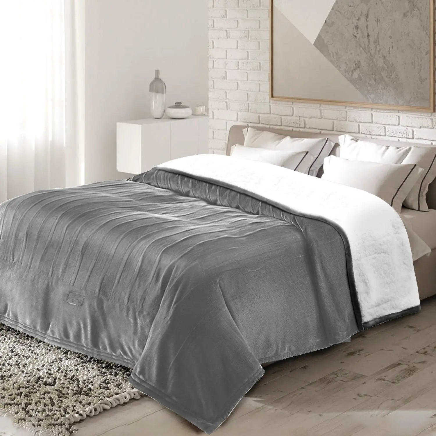 Gray and white comforter on a bed in a bedroom setting