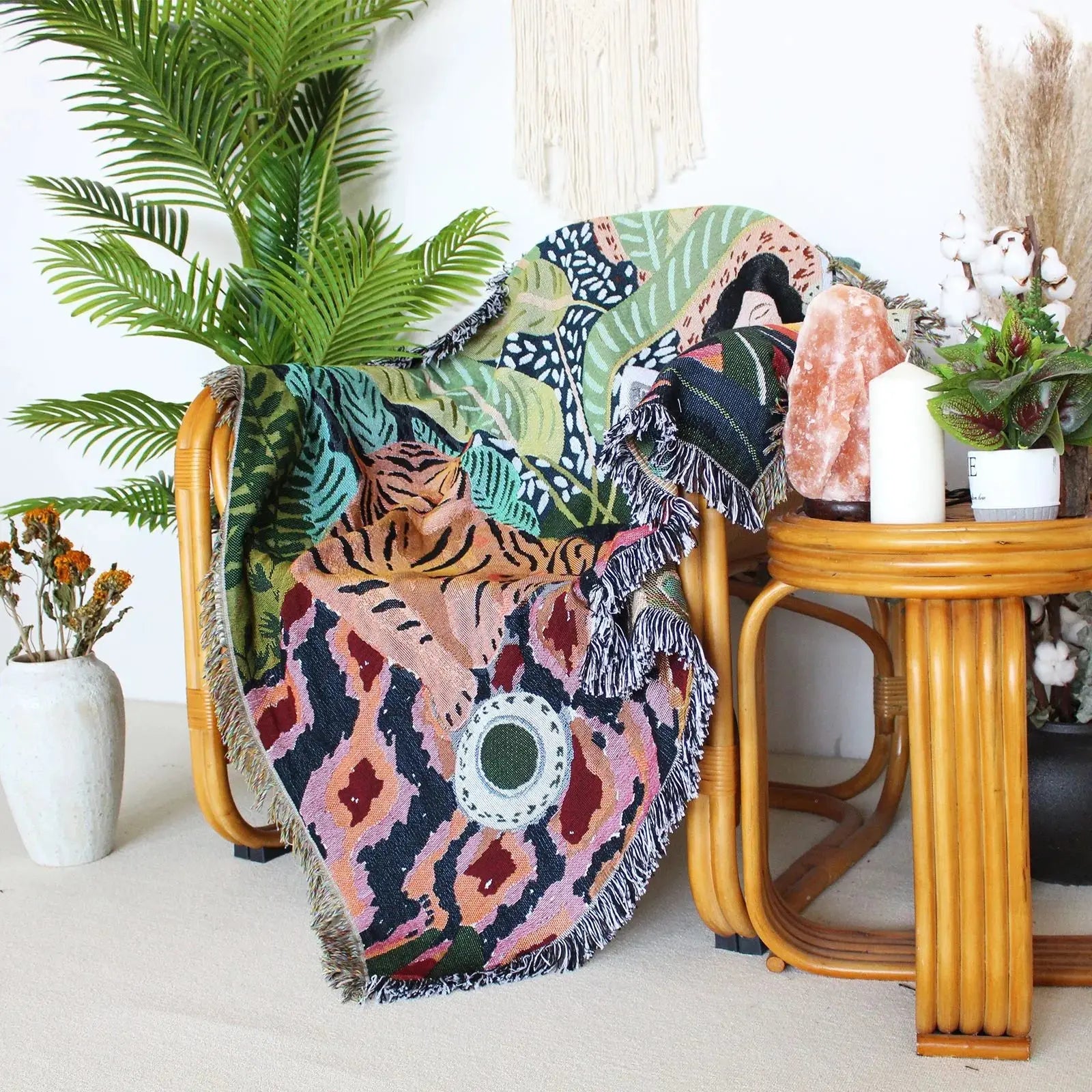 Colorful patterned blanket draped over a chair in a room with plants and decor.