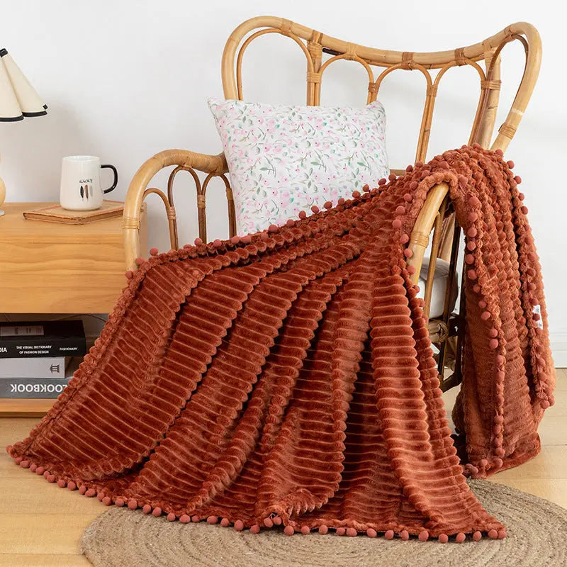 Striped flannel throw blanket with pom fringe detail ideal for bedroom layering