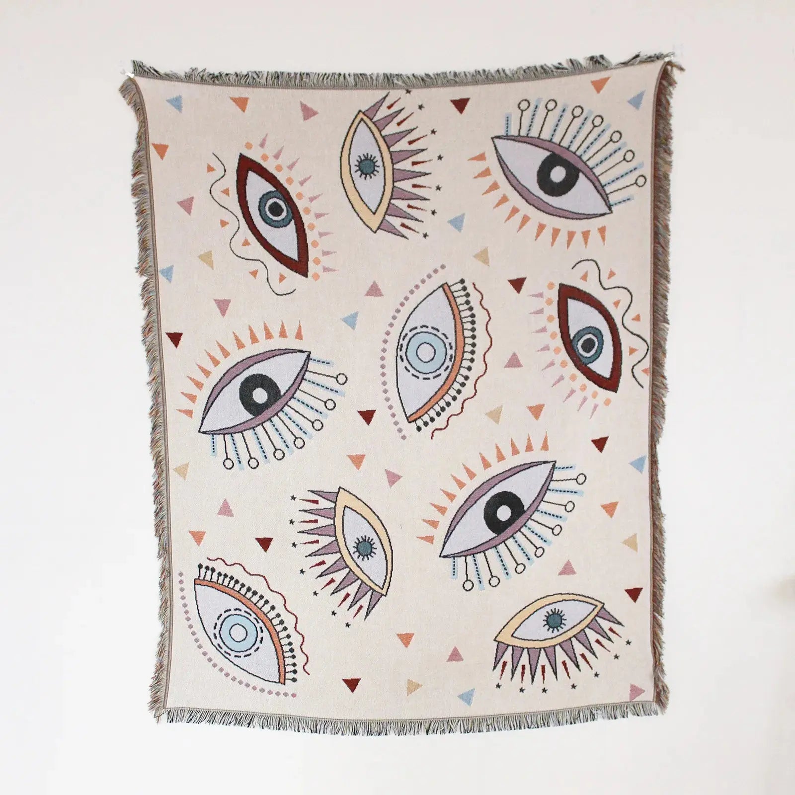 Decorative throw blanket with eye pattern on a white background