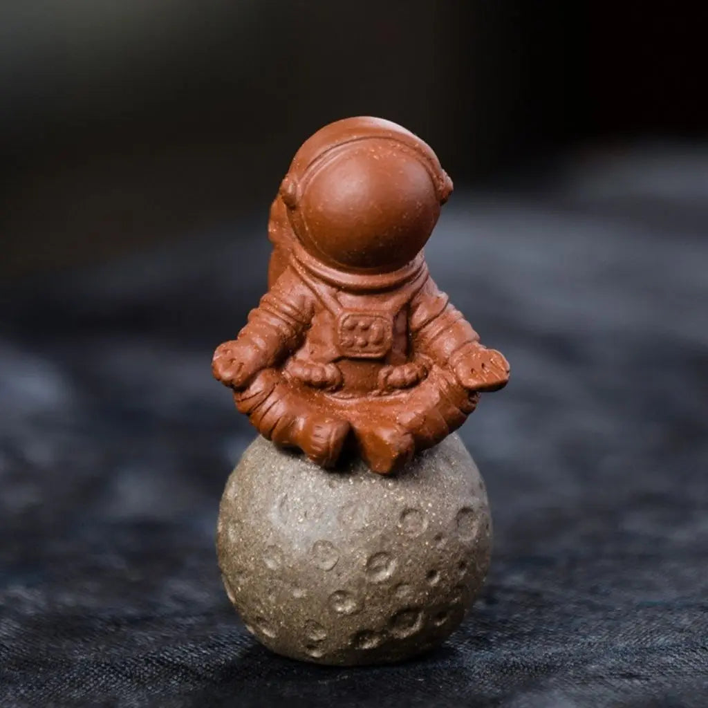 Handcrafted zisha clay astronaut tea pet sitting on moon base purple sand figurine tea table ornament