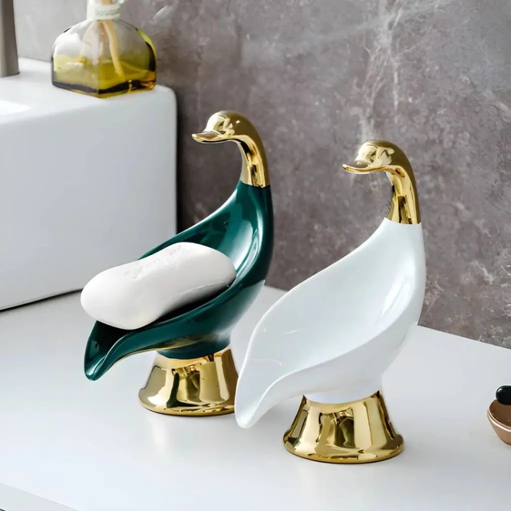 Ceramic swan bathroom accessory with gold detailing, serves as functional soap holder and vanity decor