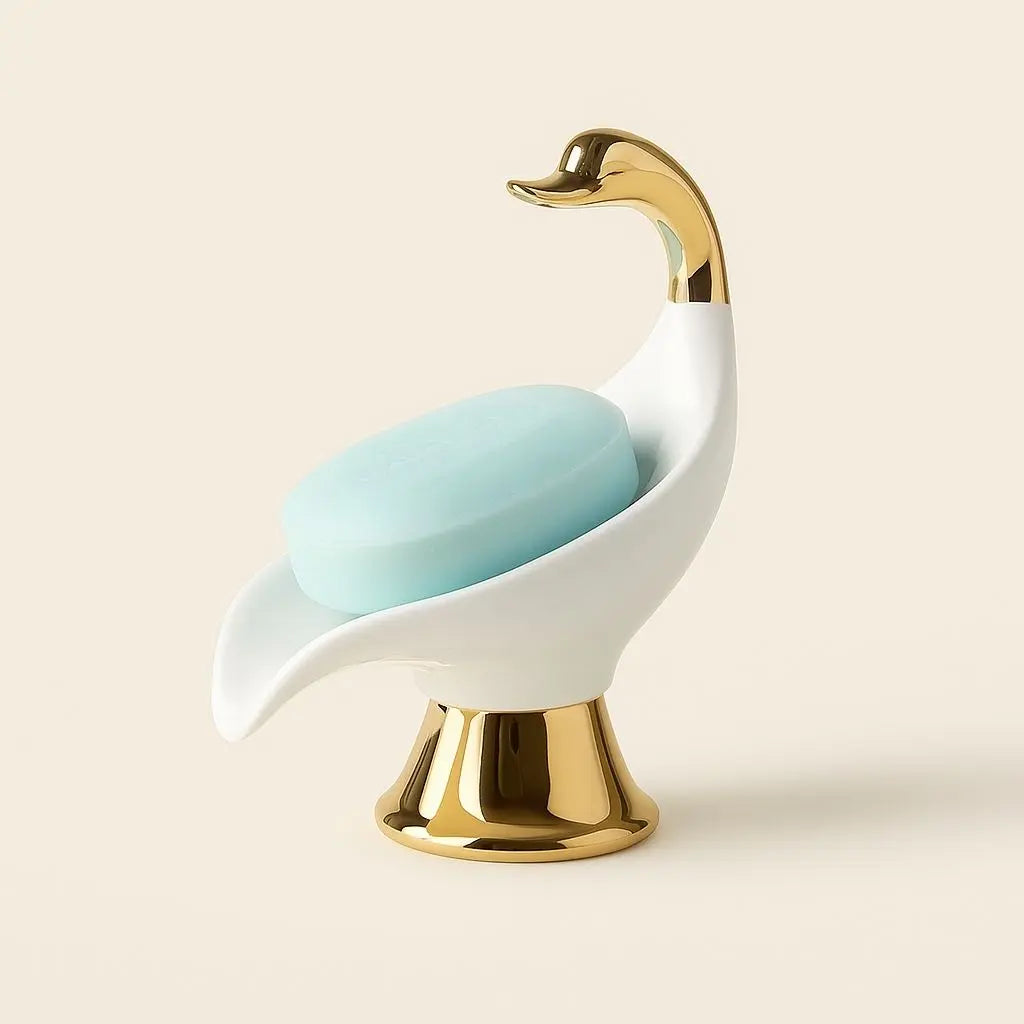 White ceramic soap dish in swan design with gold accents, ideal for bathroom and vanity organization