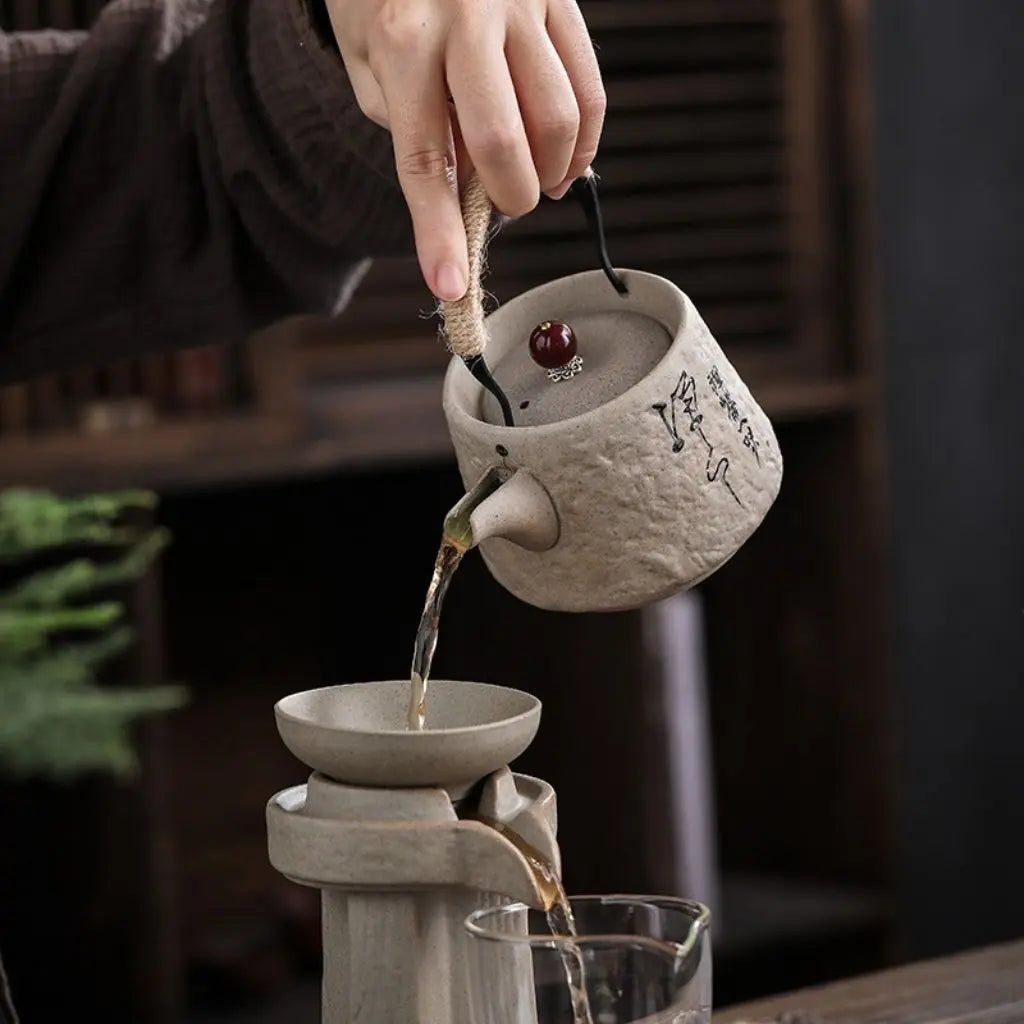 Handmade pottery teapot with rope handle design and coarse ceramic texture for authentic tea brewing experience