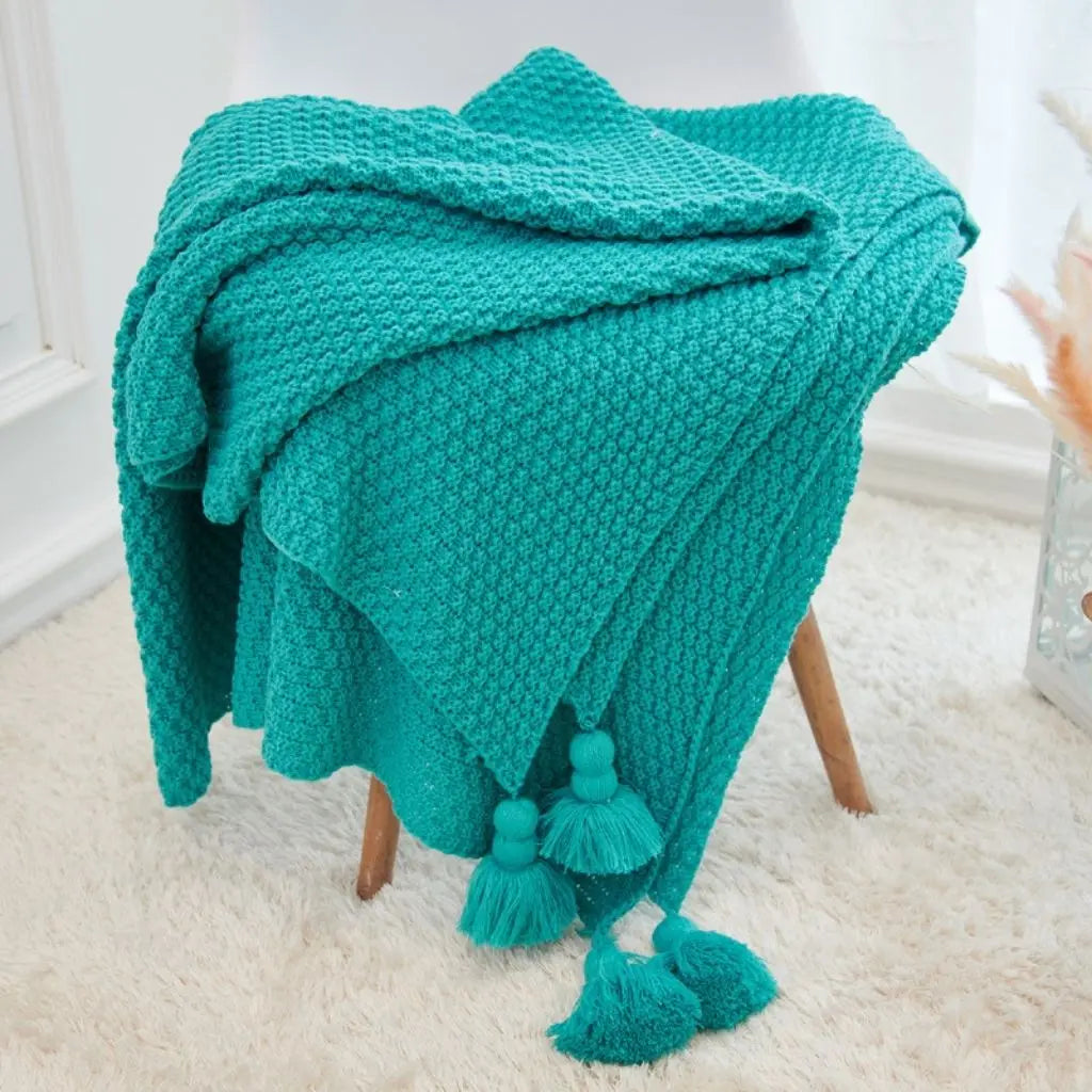 Knitted throw blanket with decorative tassels for bedroom and nursery use