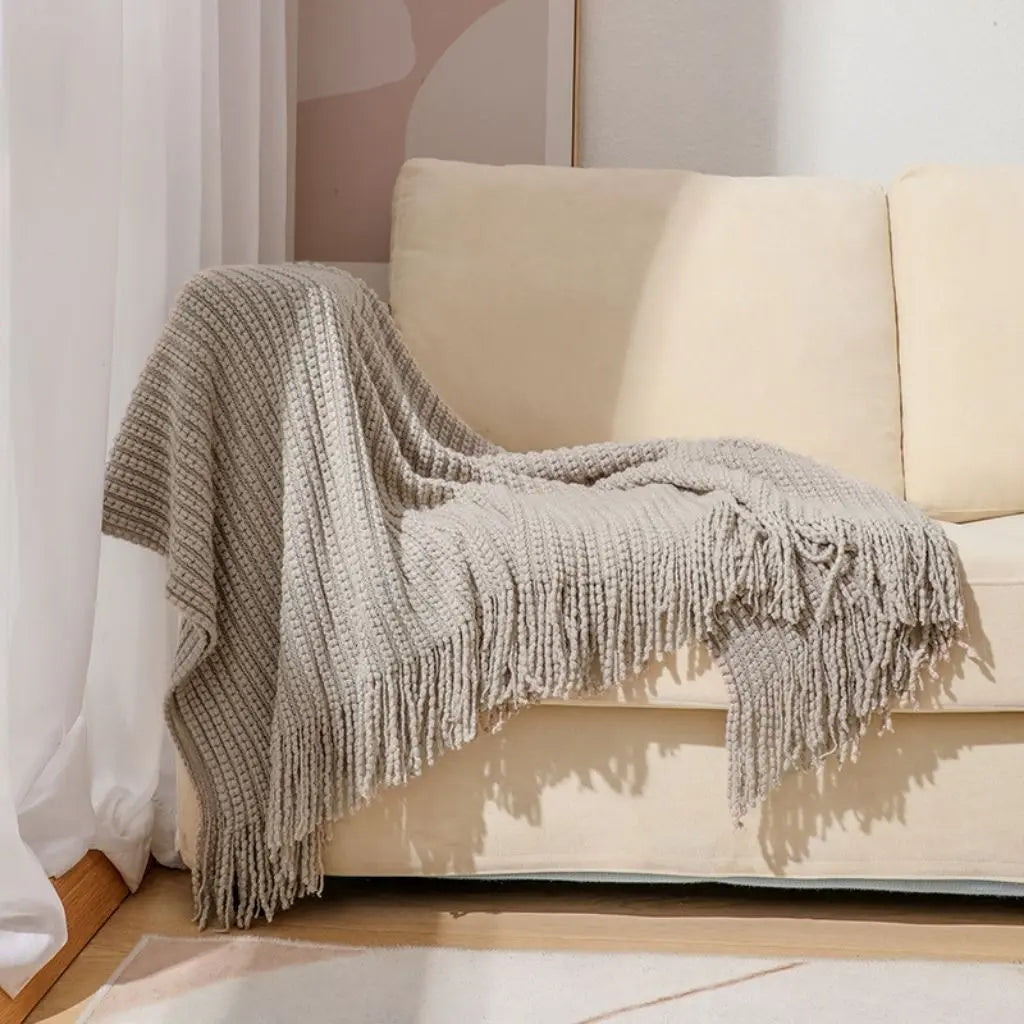 Chenille sofa throw blanket with fringe edges providing soft acrylic comfort and protection