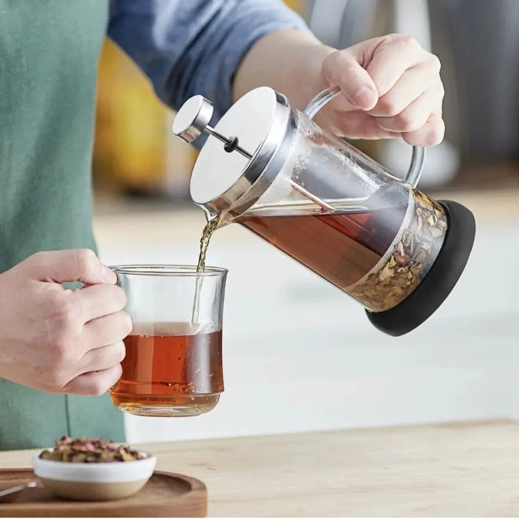 Glass french press creating creamy milk foam with dual-purpose brewing and frothing design