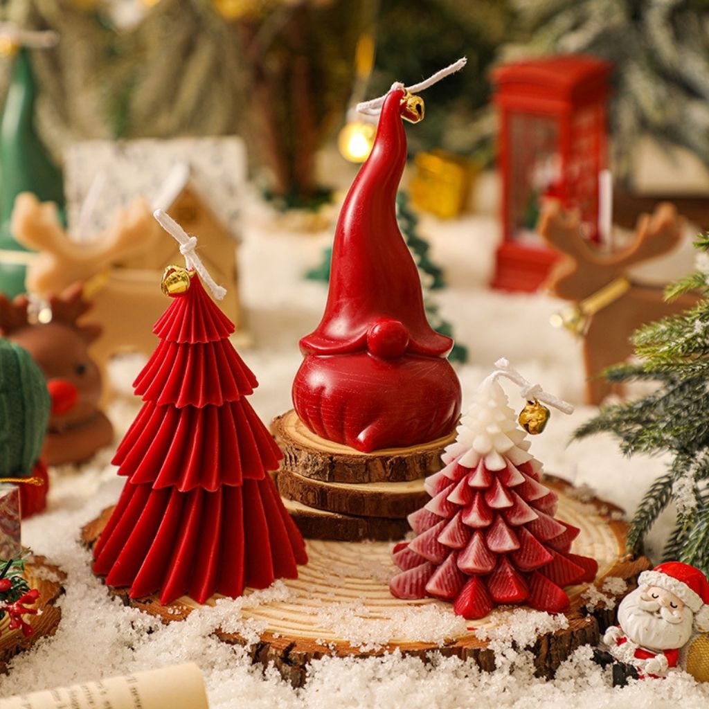 Christmas tree shaped candle with multiple tiers and decorative cord bell on tabletop
