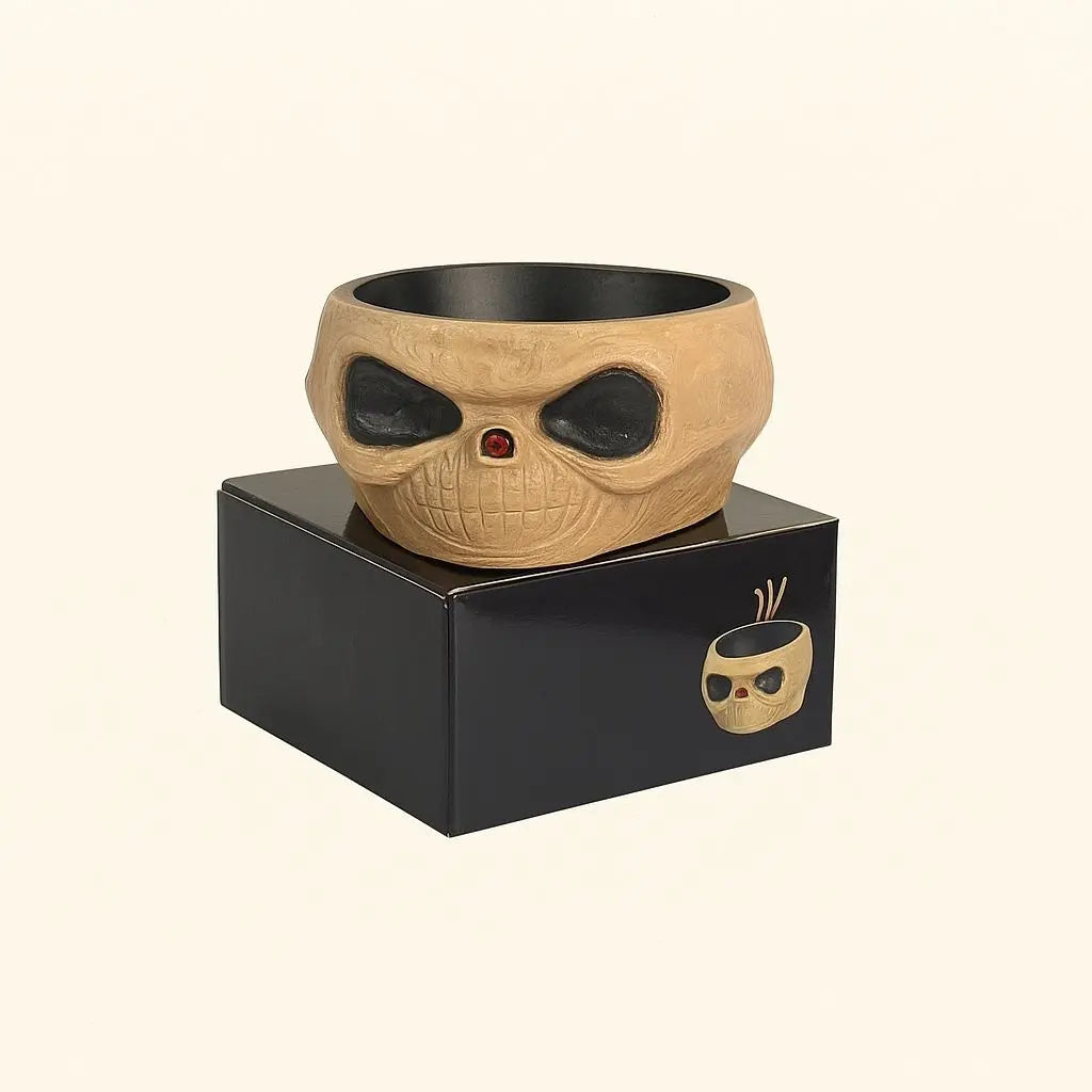 Skull-shaped bowl on a black box with a brand logo on a beige background