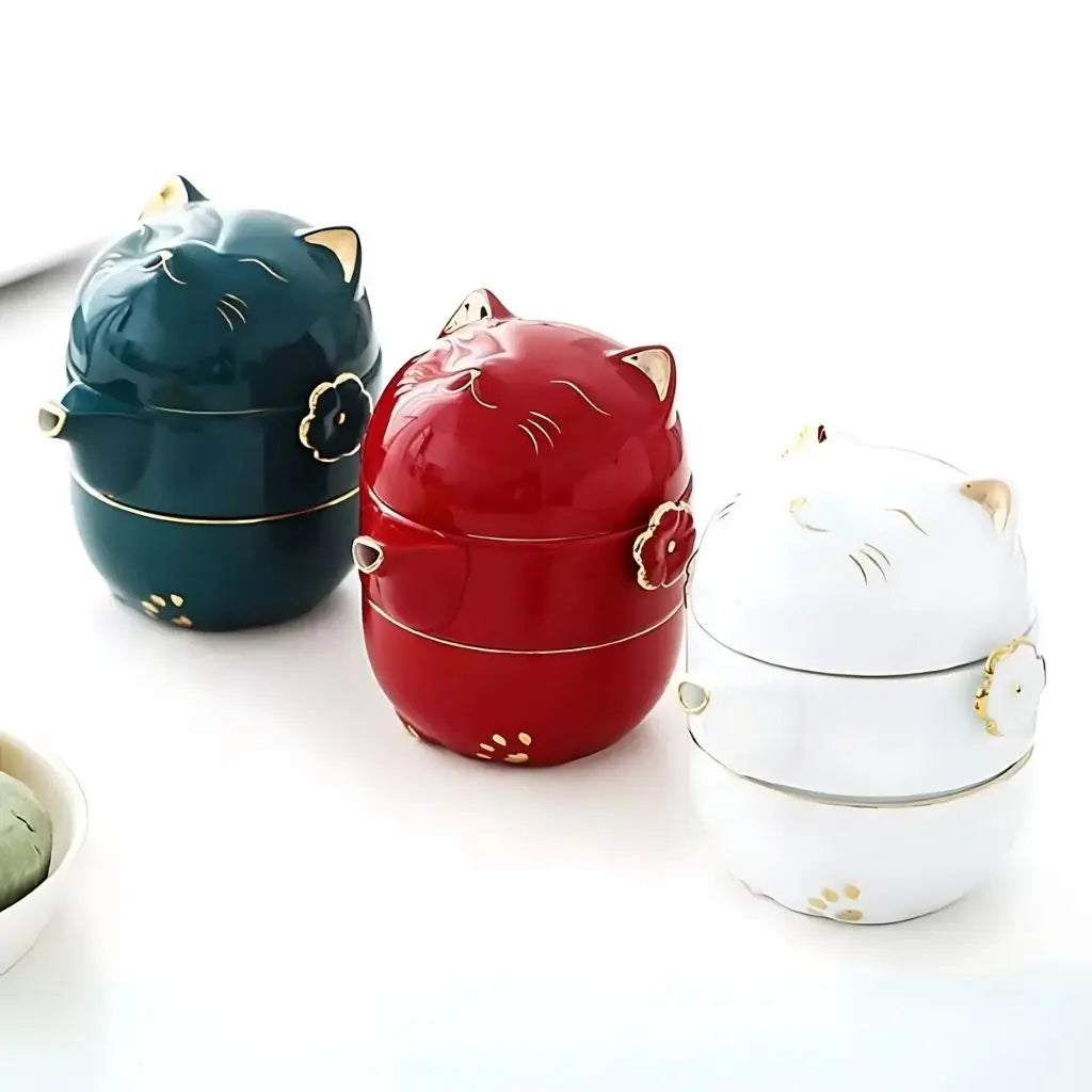 Three cat-shaped ceramic containers in green, red, and white on a white background