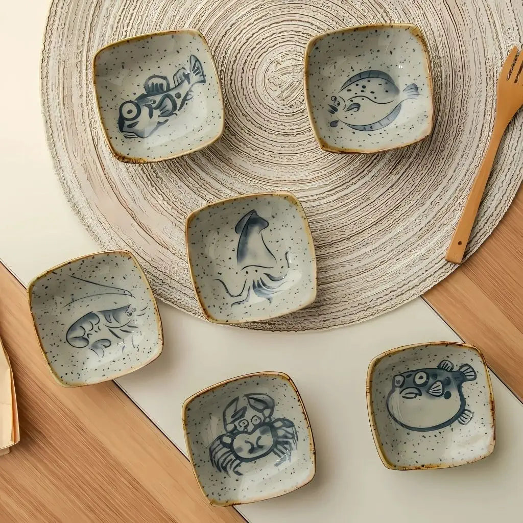 Speckled ceramic glaze with intricate sea life motifs creating unique coastal dining aesthetic