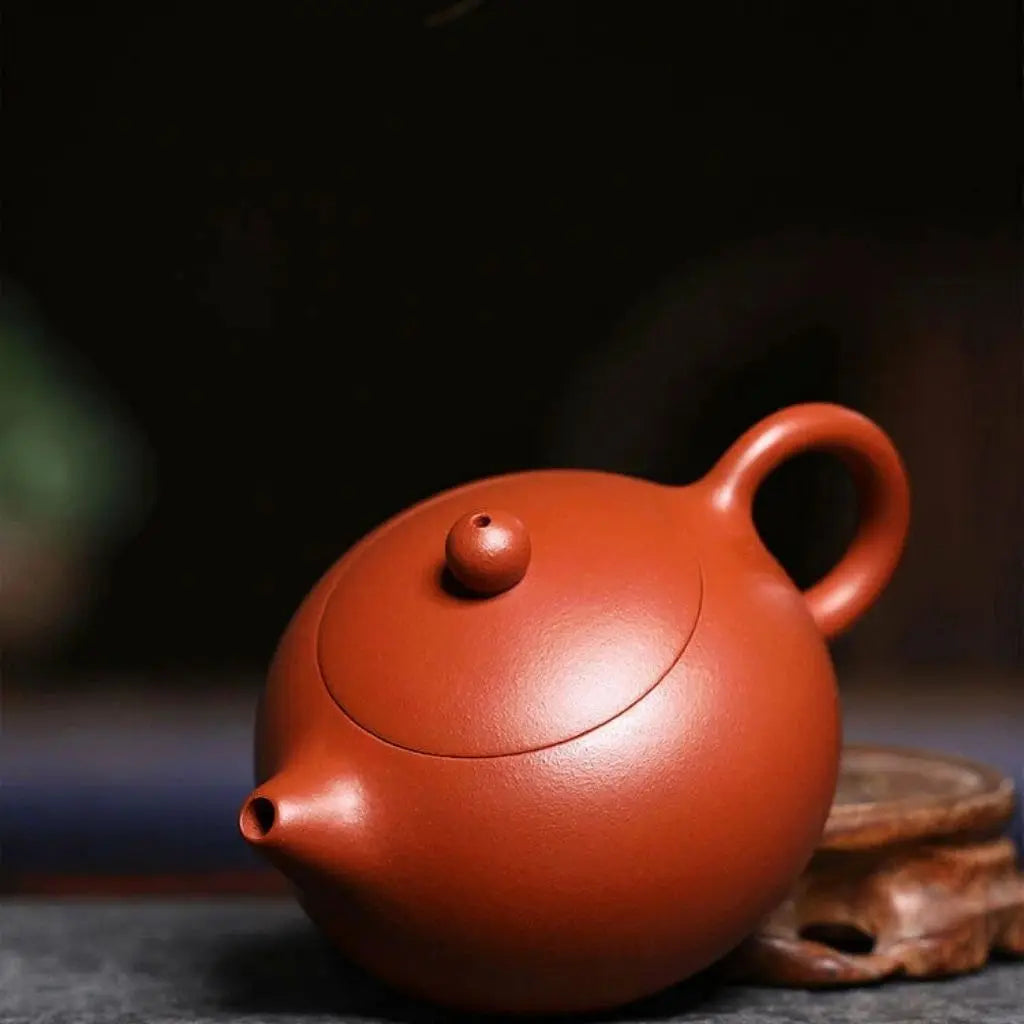 Elegant red clay ceramic teapot displayed on tea table, ideal for home tea ceremonies and daily brewing