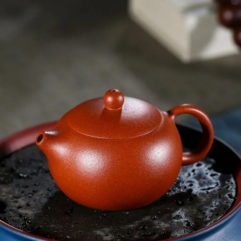 Close-up of handmade red clay ceramic teapot showing rich terracotta texture and artisan craftsmanship