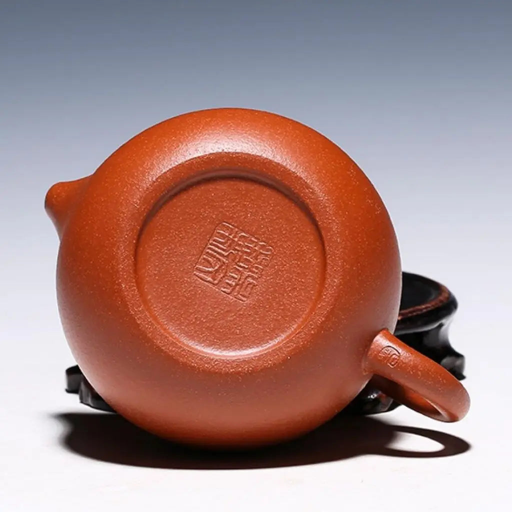 Red clay ceramic teapot in use for traditional tea brewing, perfect for loose leaf tea and tea ceremonies