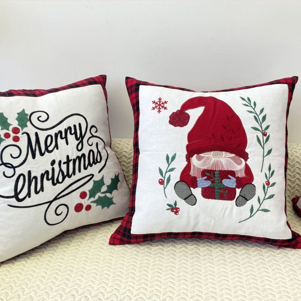 Seasonal cushion cover with embroidered holiday greeting and plaid edge