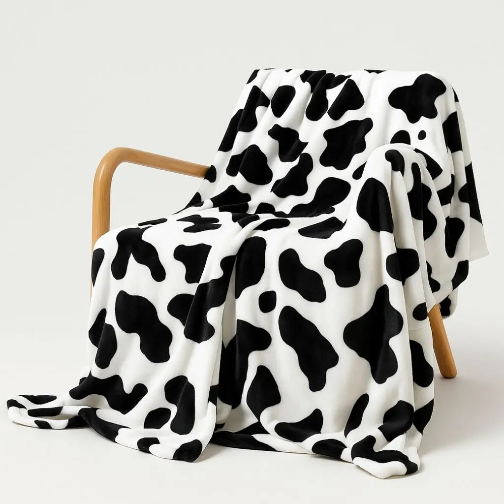 Soft flannel cow print blanket with bold black white pattern, perfect cozy throw for farmhouse home decor