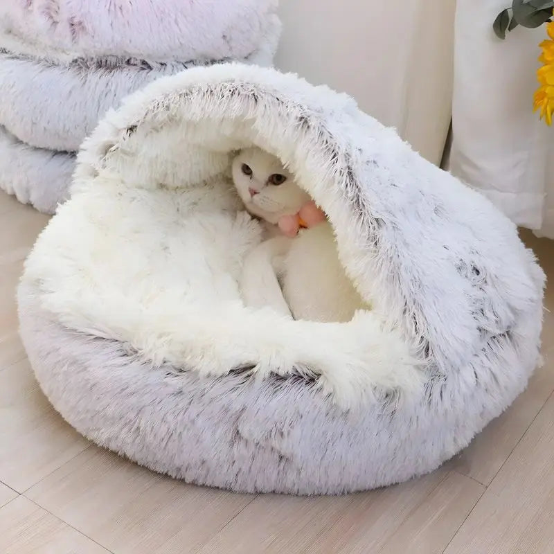 Cat sitting inside a fluffy white pet bed on a light wooden floor.