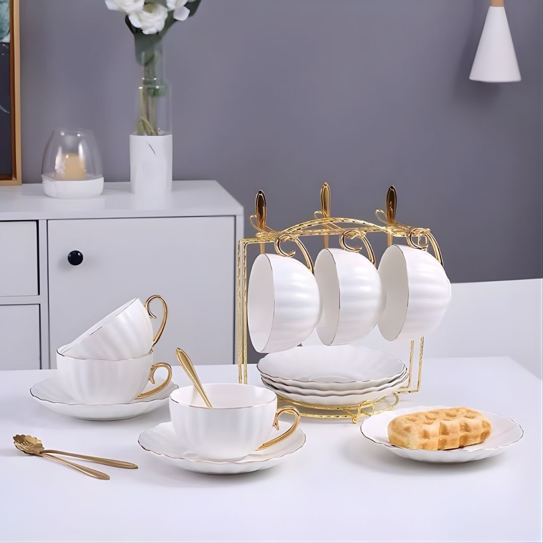 Ceramic tea cup with gold detailing includes matching saucer and decorative spoon for tea service
