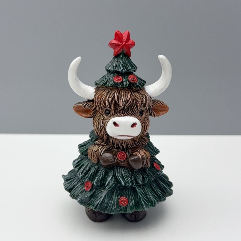 Festive cattle ornament featuring detailed sculpted head and holiday tree costume