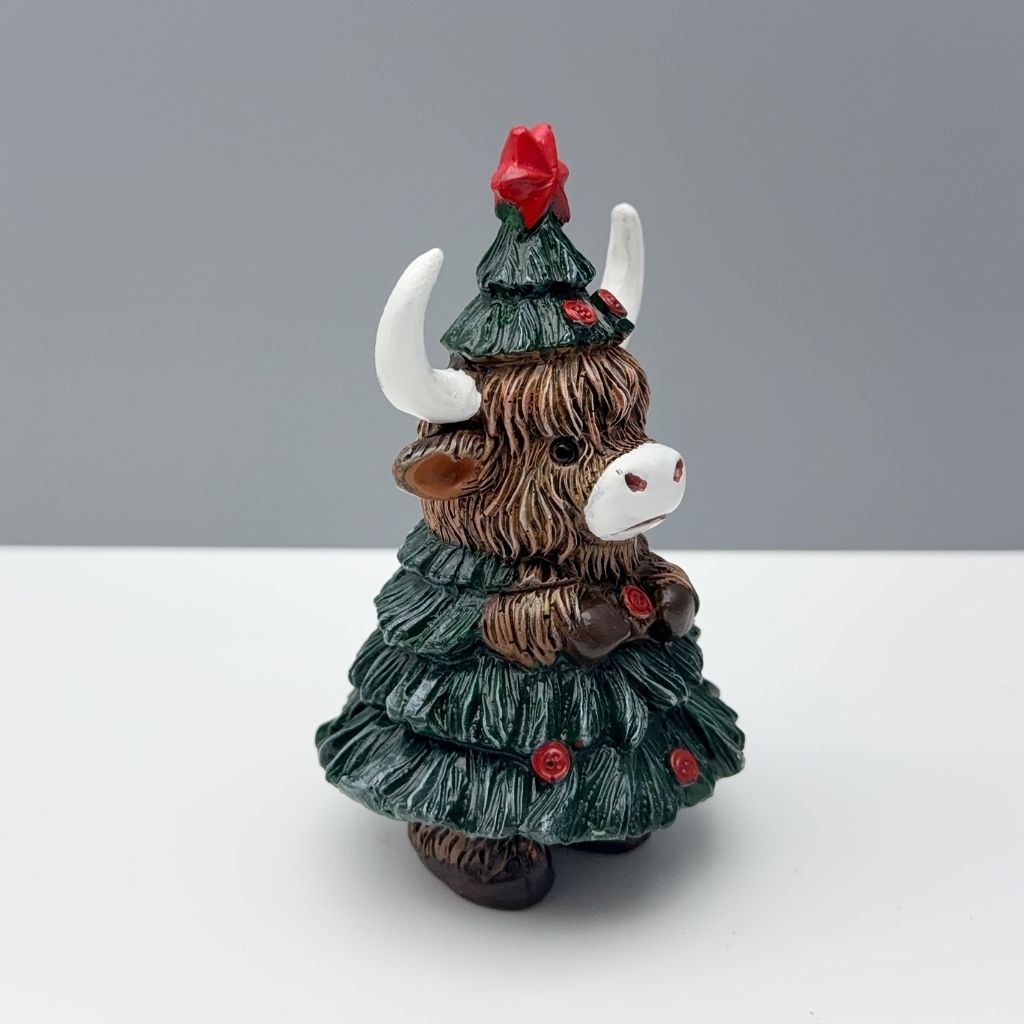 Compact resin decoration showing highland cow with seasonal tree design