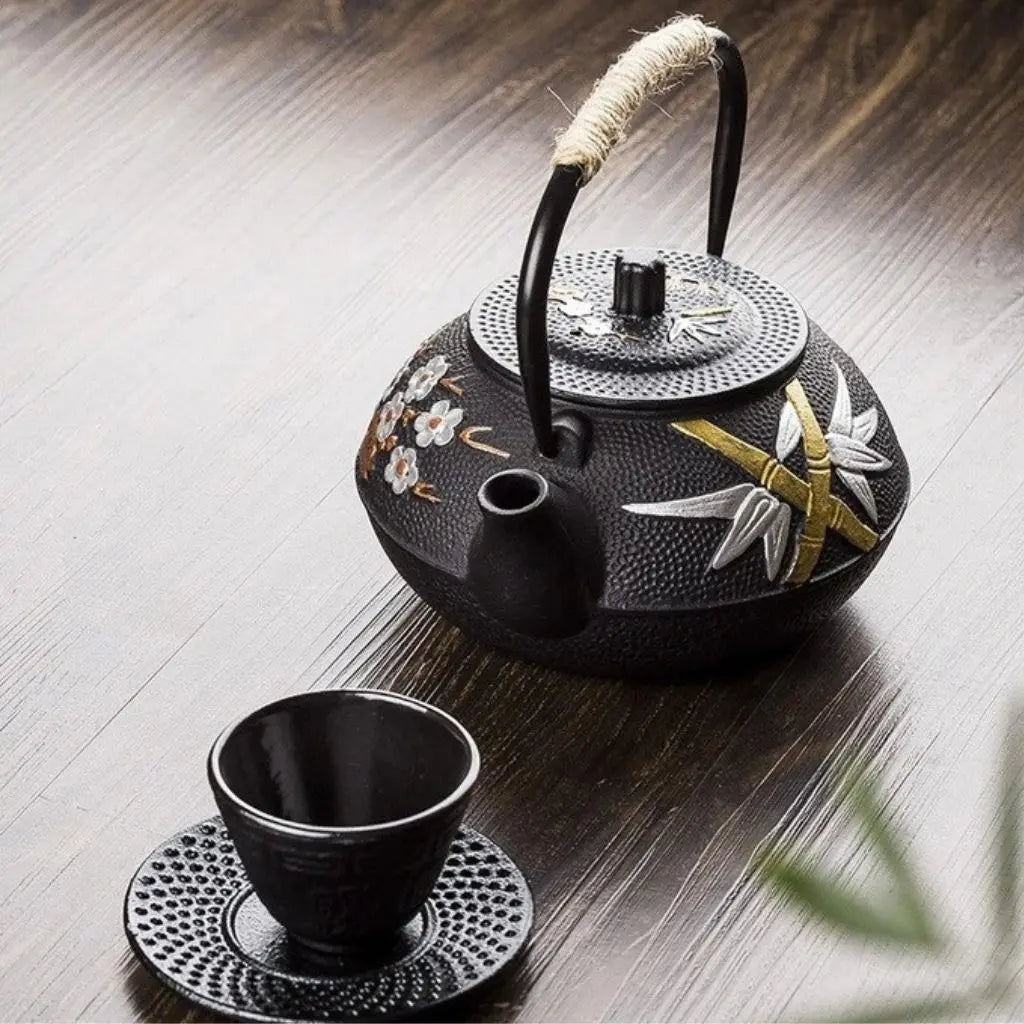 Detailed view of cast iron teapot showcasing intricate plum blossom artwork and traditional Japanese styling