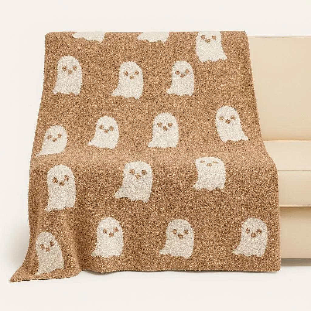 Decorative knit blanket with ghost motif design, crafted from soft polyester for lounging comfort