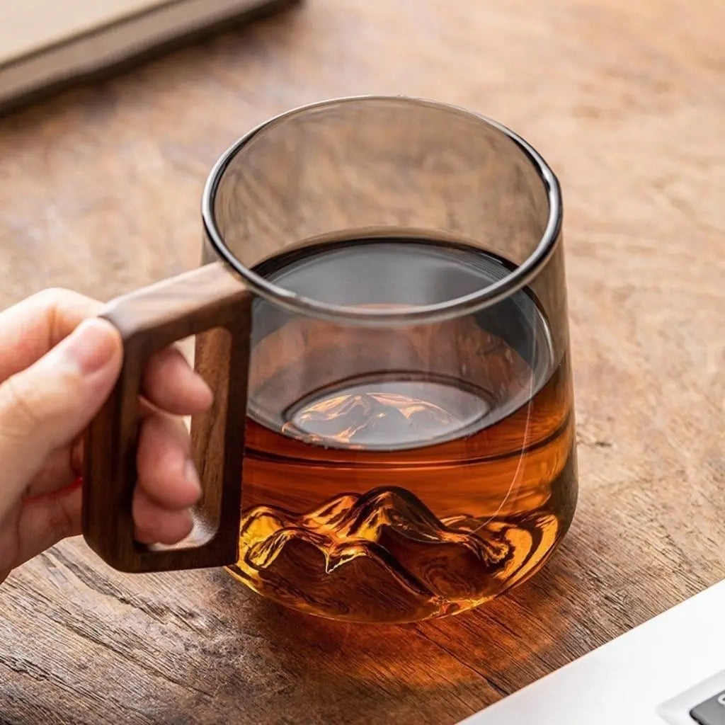 Glass coffee mug with natural wooden side handle showcasing heat-resistant borosilicate construction