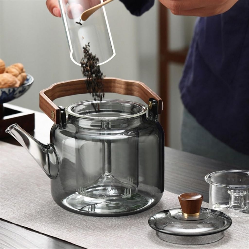 Close-up of premium borosilicate glass teapot showcasing natural ashwood handle and integrated tea infuser