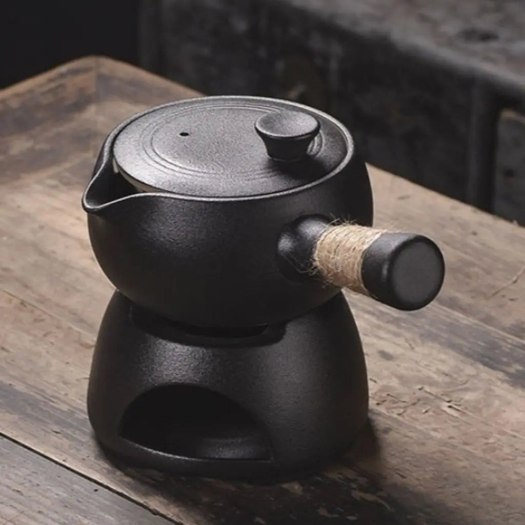 Black cast iron teapot on a wooden surface