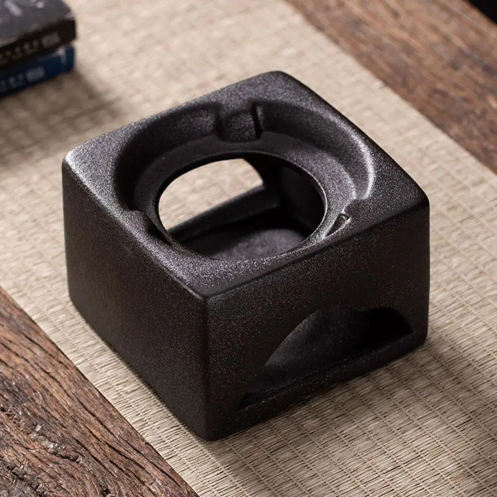 Matching ceramic warming furnace base for stoneware tea pot with functional heating design