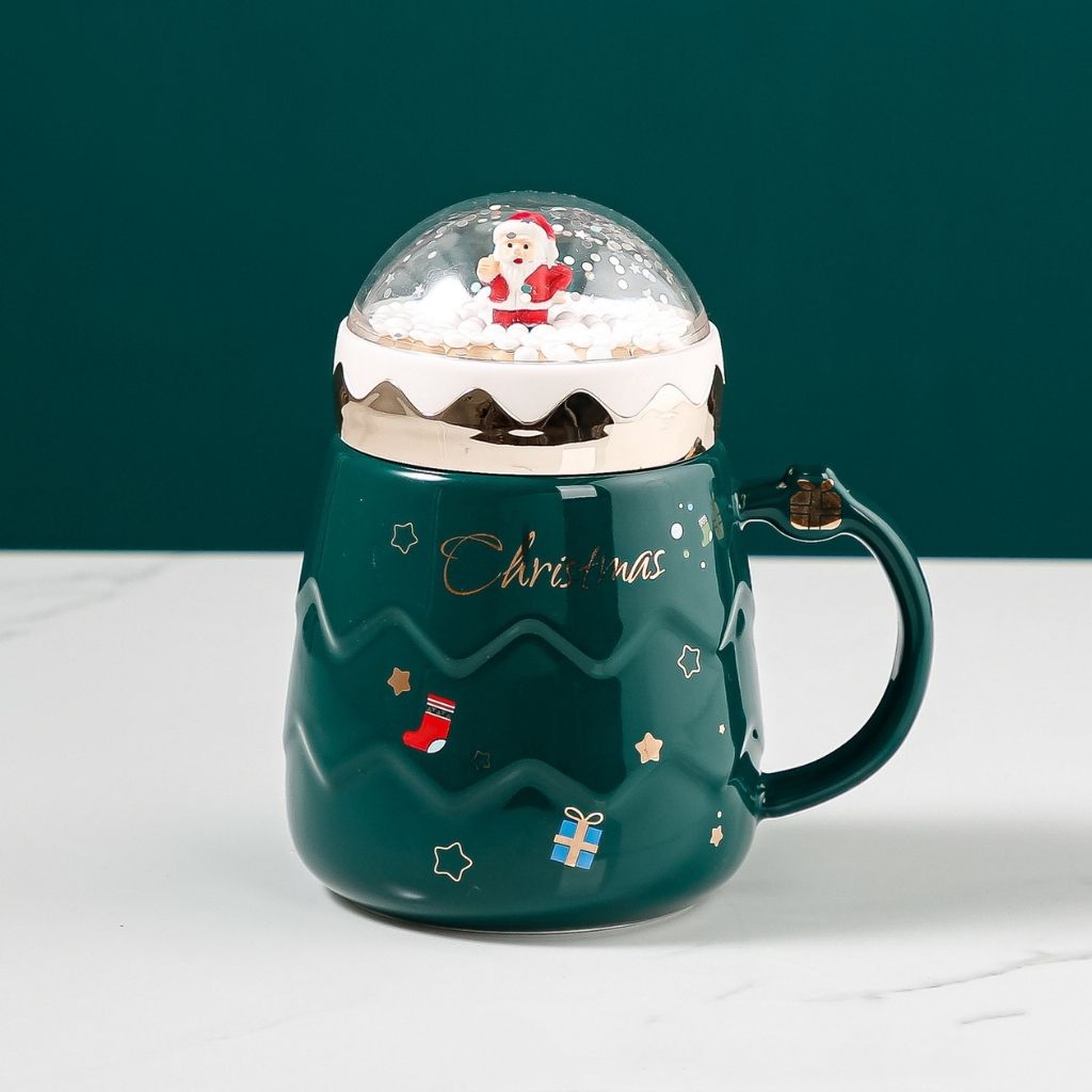 Holiday ceramic mug featuring snow globe lid and comfortable handle for hot beverages
