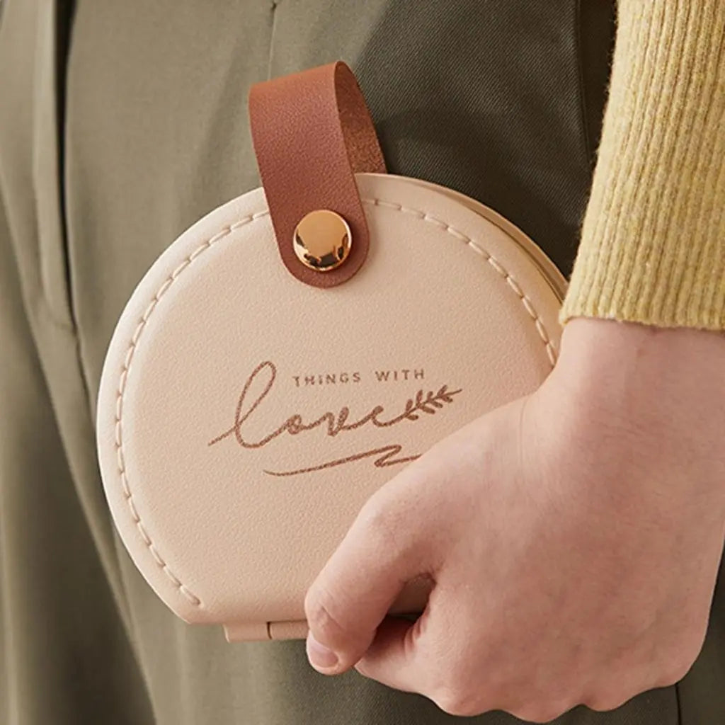 Round sewing repair kit with snap closure showing organized compartments for threads and crafting tools