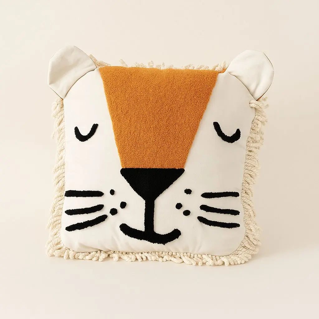 lion-shaped pillow with a white face, orange tabby pattern, and black accents on a beige background