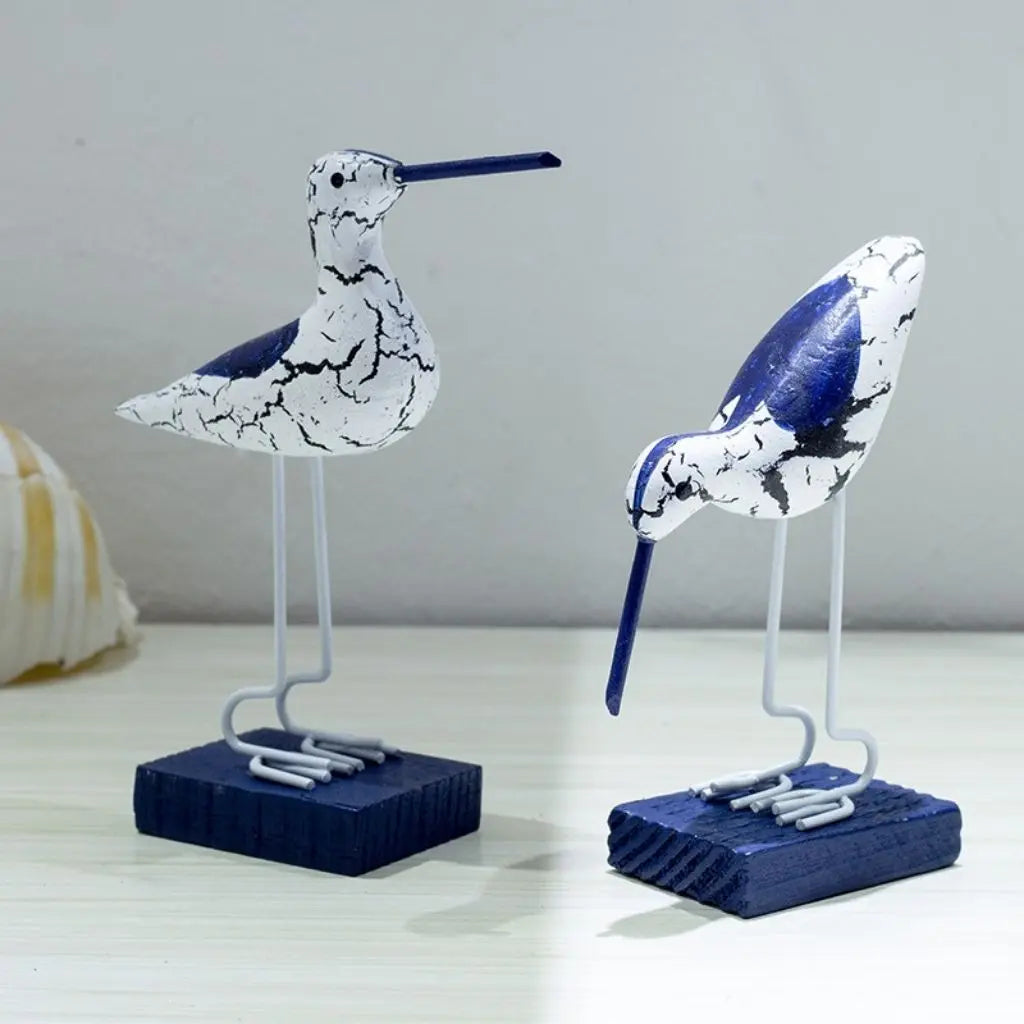 Two decorative bird figures on stands with a white background