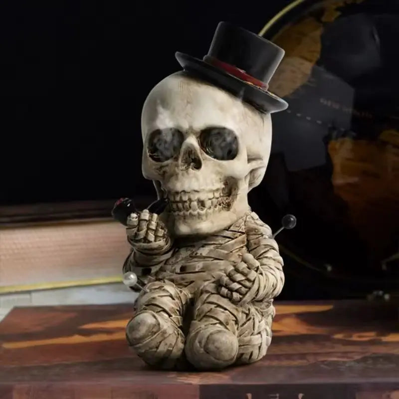 Skull figurine wearing a top hat and holding a pipe on a wooden surface.