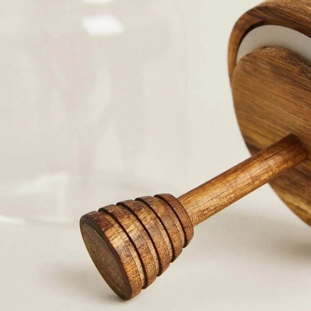 Wooden honey dipper on a light background