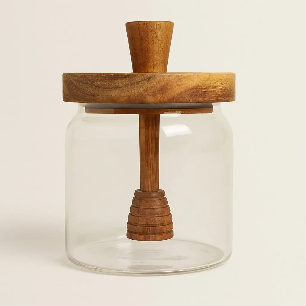 Glass honey jar with a wooden lid and handle on a beige background