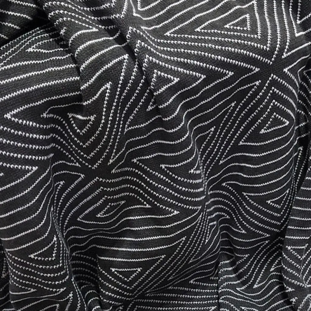 Modern knit blanket displaying nordic aesthetic in contrasting black white tones for home styling