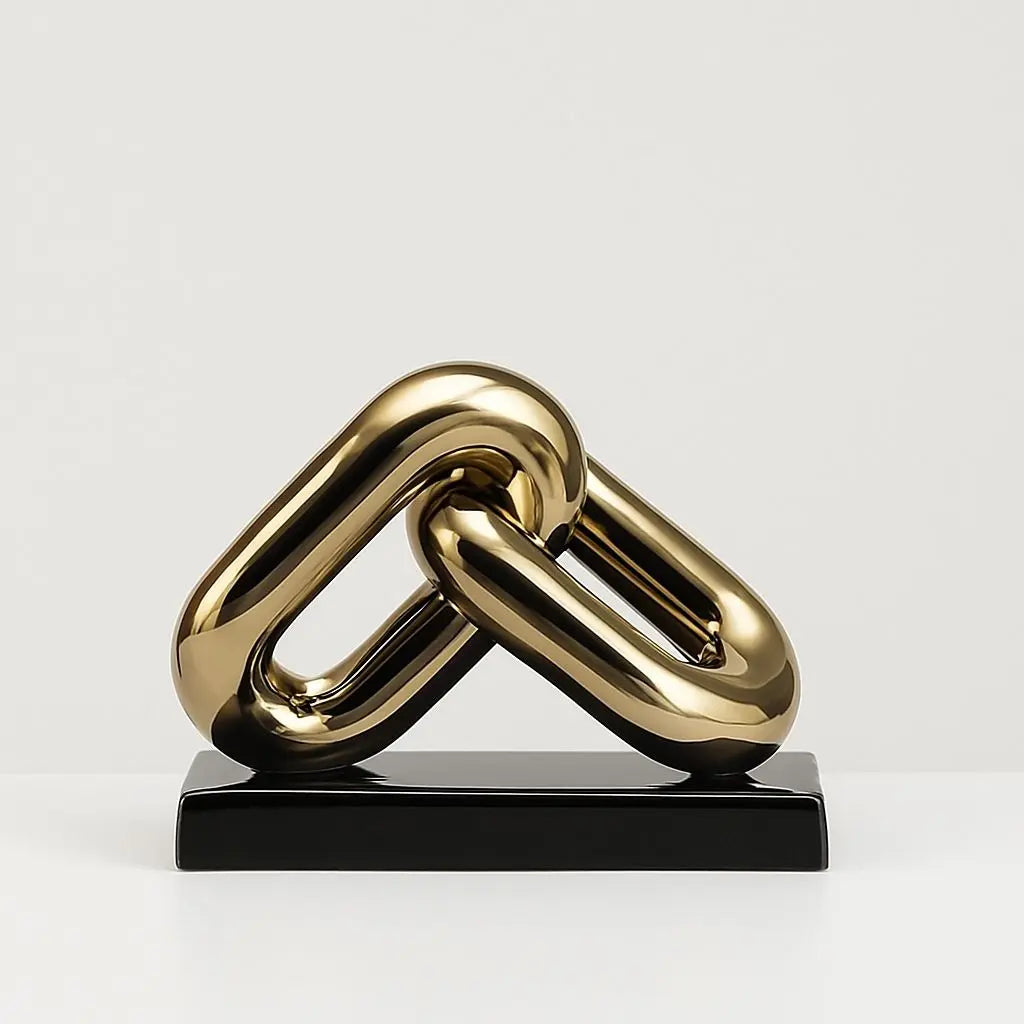 Gold chain-like sculpture on a black base against a light gray background
