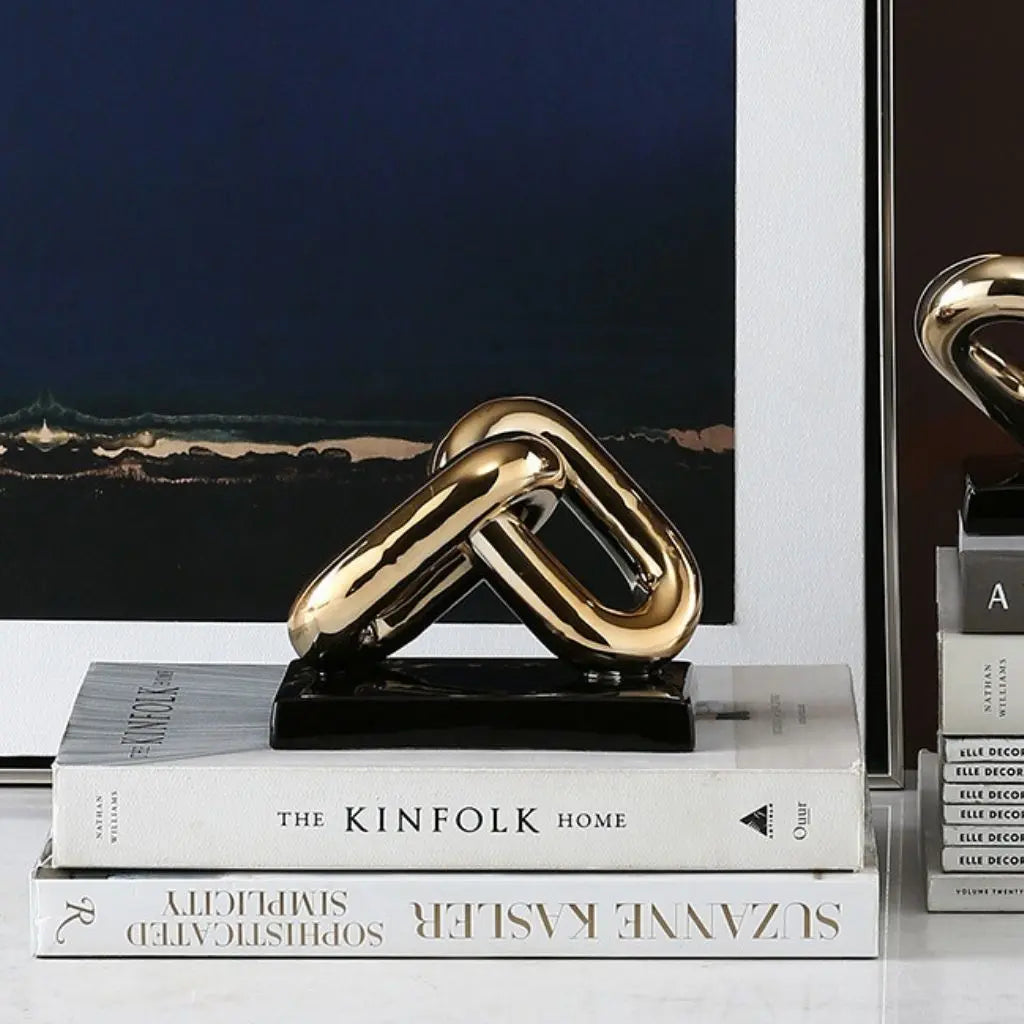 Gold chain-like sculpture on books with a blurred background