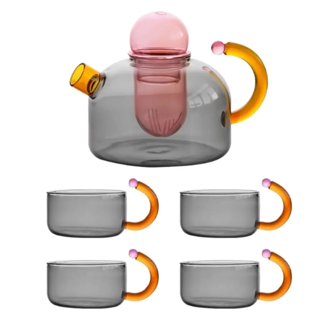 Glass teapot with pink lid and orange handles, accompanied by four matching glass cups with orange handles on a white background.