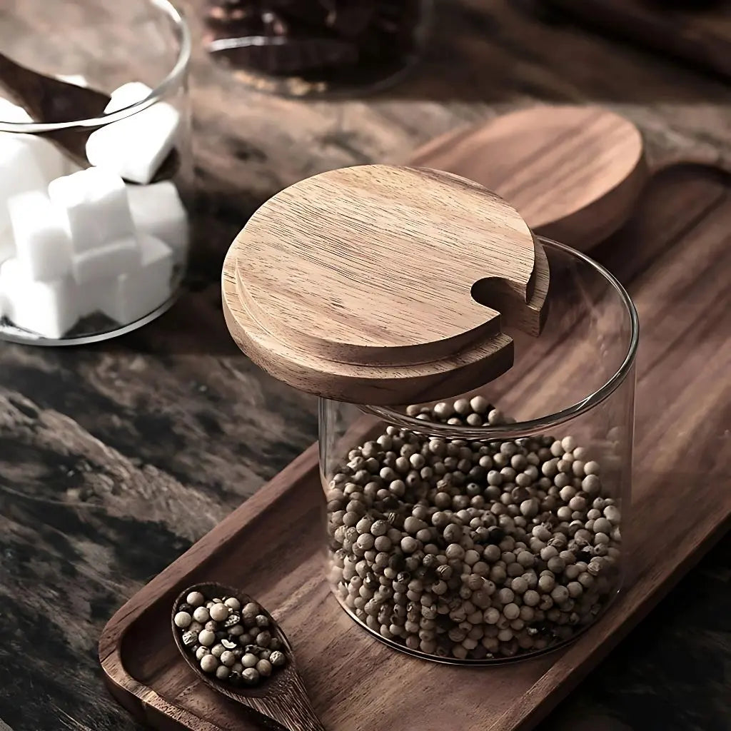 Mason jar seasoning containers with rustic wooden tops for organized pantry storage.