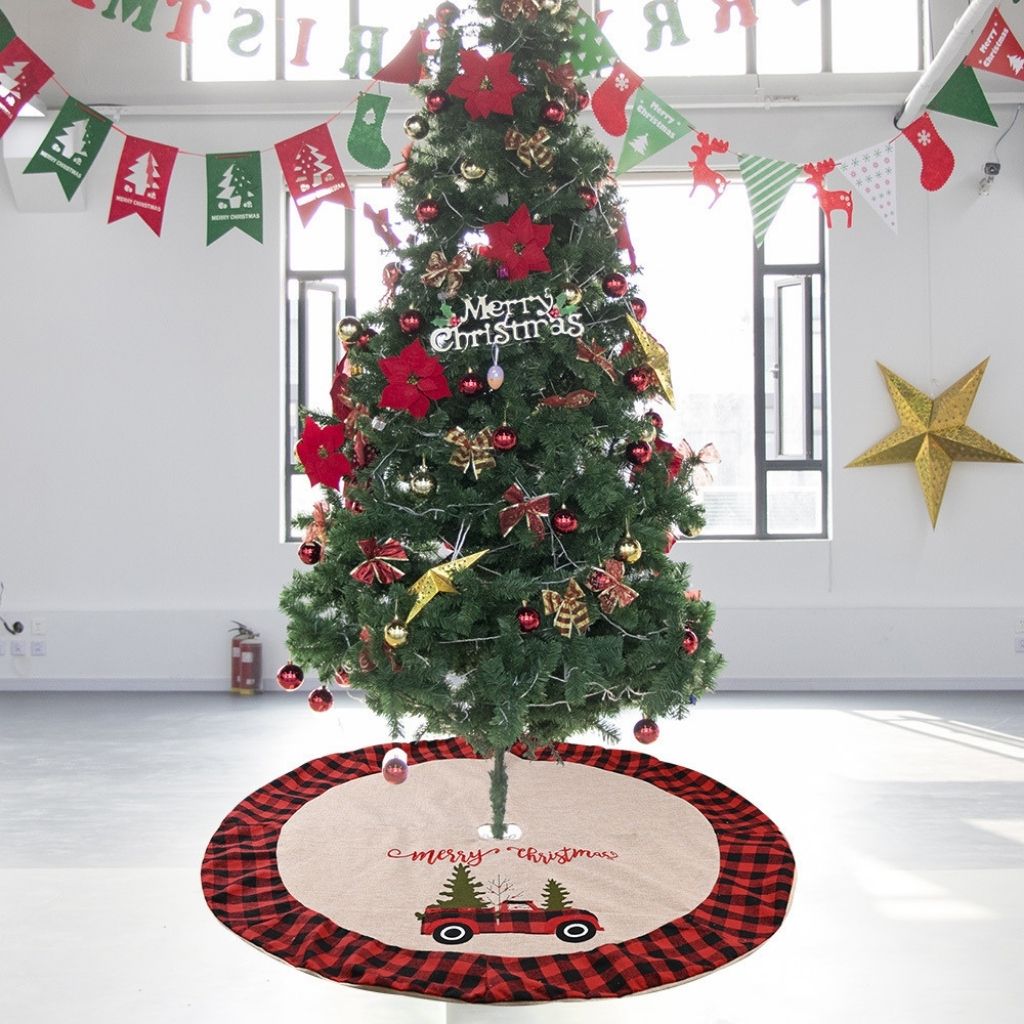 Red and black buffalo plaid Christmas tree skirt with vintage truck carrying evergreen trees