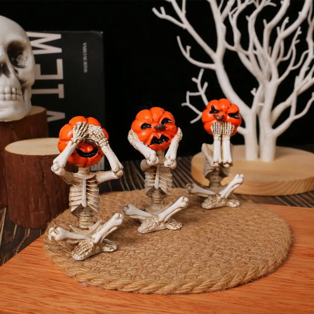 Halloween-themed decorations with skeleton hands and pumpkin faces on a wooden surface.