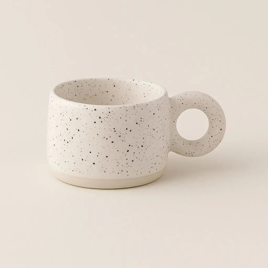Speckled ceramic mug on a beige background