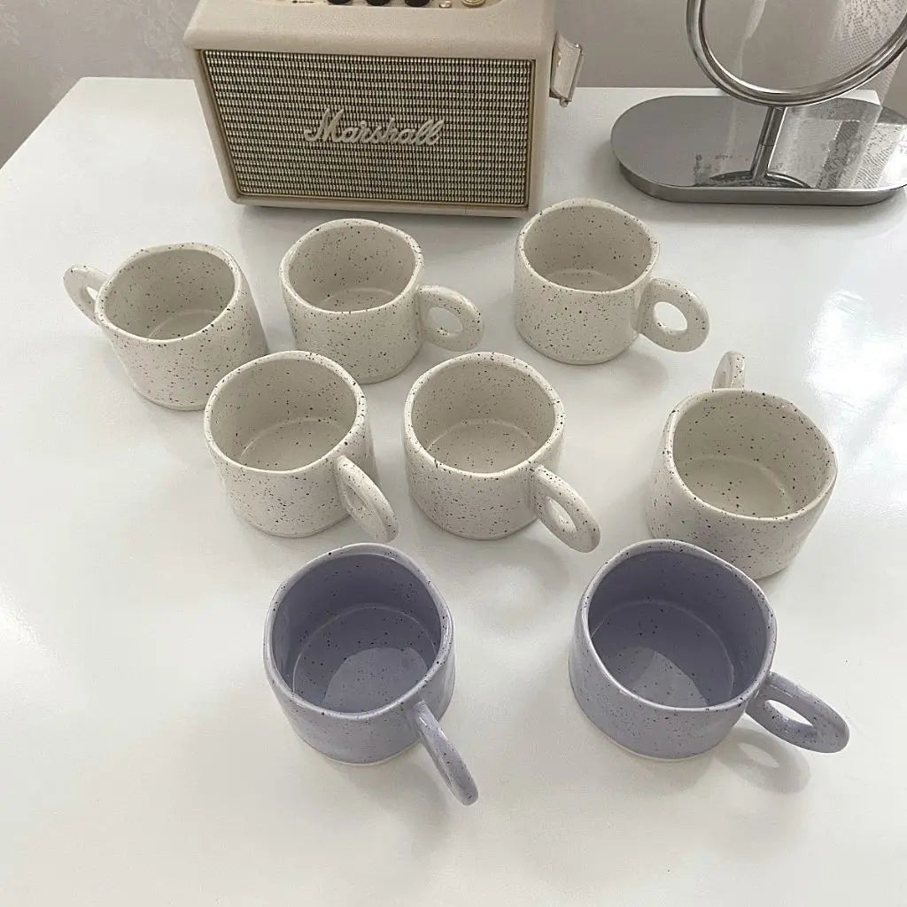 Speckled ceramic coffee mug filled with coffee showcasing practical daily use and artistic design.