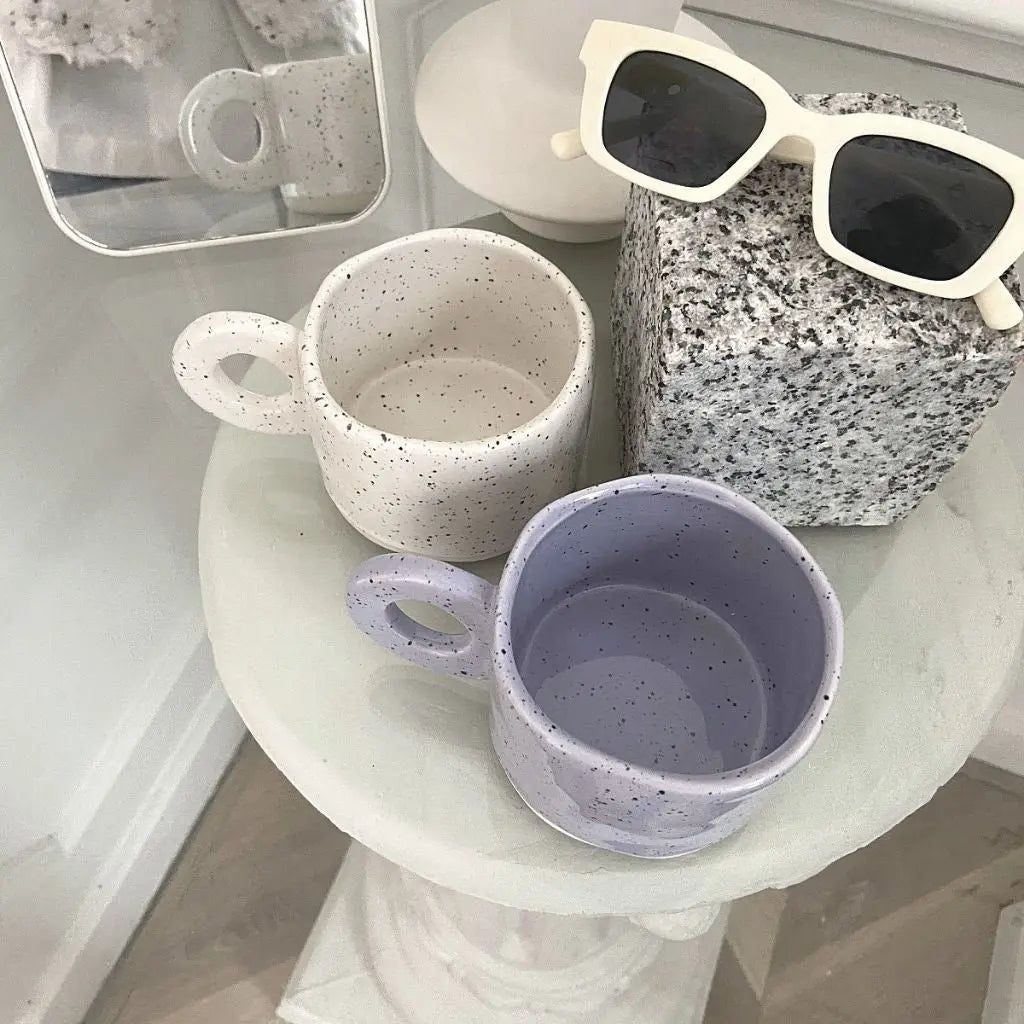 Collection view of speckled ceramic coffee mugs displaying unique glaze patterns and craftsmanship.