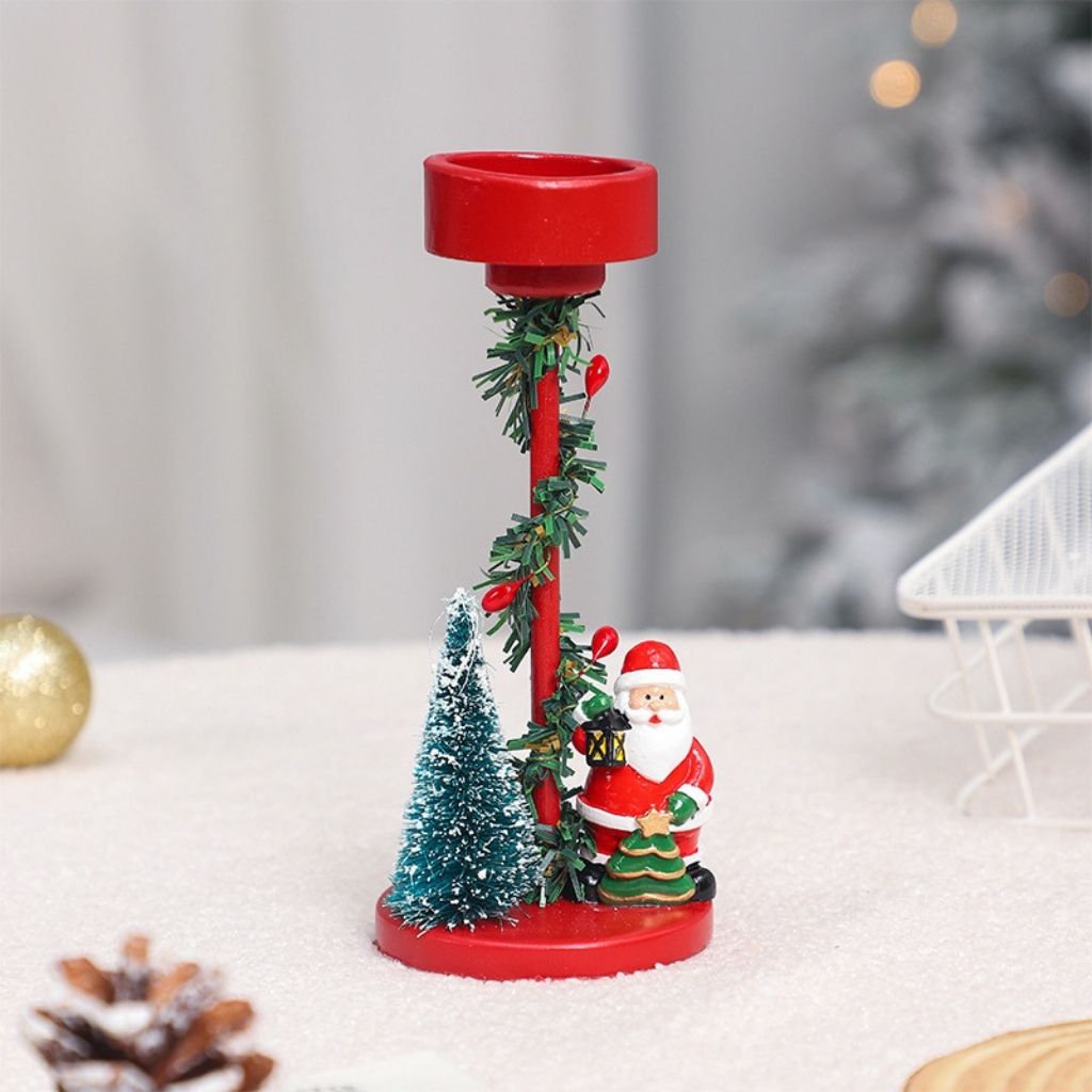 Seasonal candle stand with miniature winter display and evergreen accents on cylindrical base